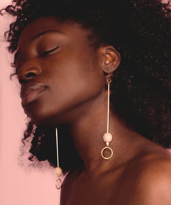 a model wearing the earrings that are long enough to touch the shoulder