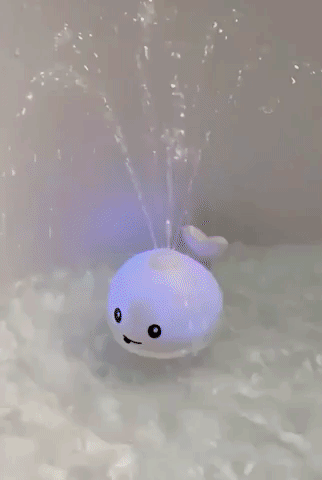 reviewer's gif of the whale bath toy in action