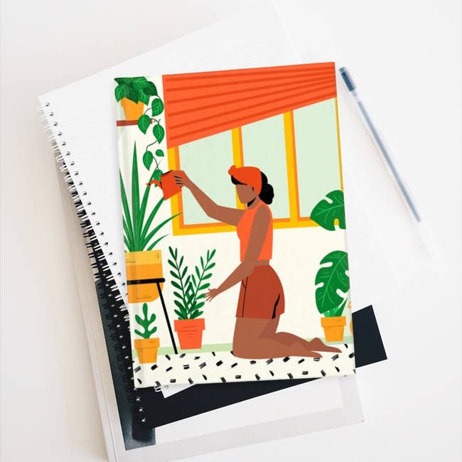 the hardcover notebook with illustration of Black woman watering plants