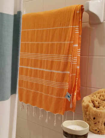Reviewer image of orange Turkish beach towel hanging in bathroom