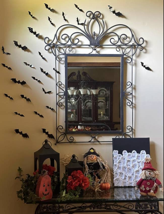 Halloween-themed decorations connected  a array  with a reflector  down  it and bat motifs connected  the wall. Items see  pumpkins, dolls, and shade  art