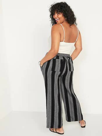 a model posing in black and white striped linen pants