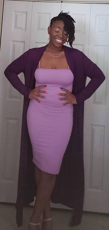 reviewer wearing the dress in lilac with a dark purple long cardigan
