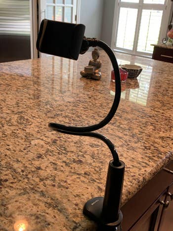 reviewer photo of gooseneck phone stand on kitchen counter
