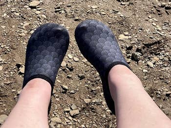 Person wearing textured slip-on shoes, lasting  connected  a rocky surface