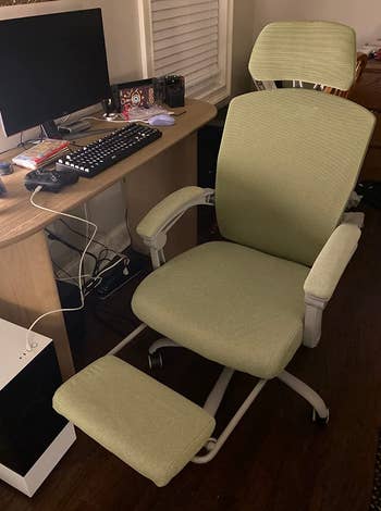 a reviewer photo of the chair in green with the recliner extended 
