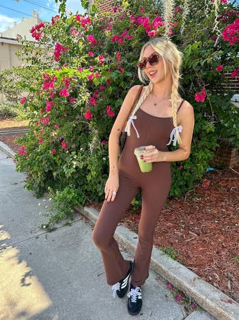 a reviewer wearing the dark brown jumpsuit