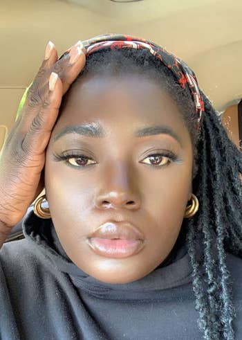 reviewer with moisturizer and makeup on their face, looking super glowy and hydrated
