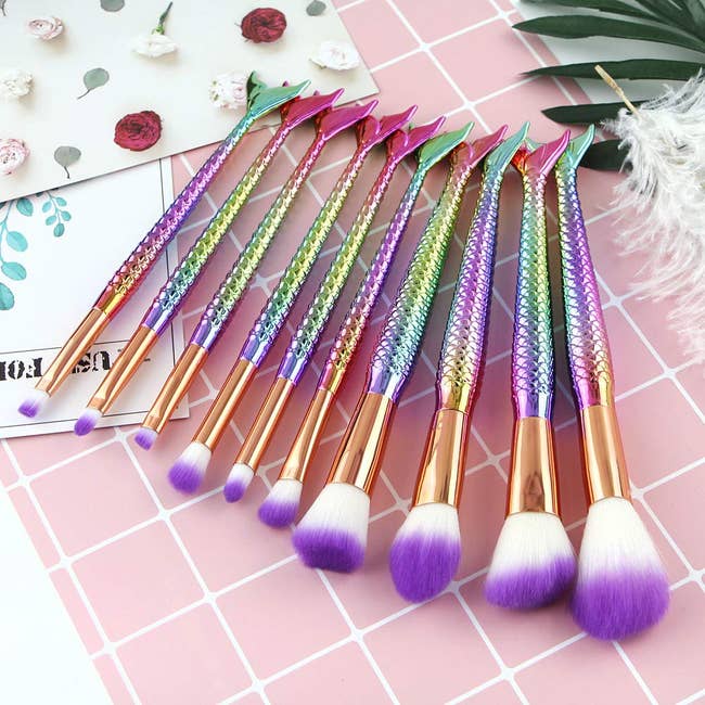 the brushes with rainbow tail handles and purple and white bristles