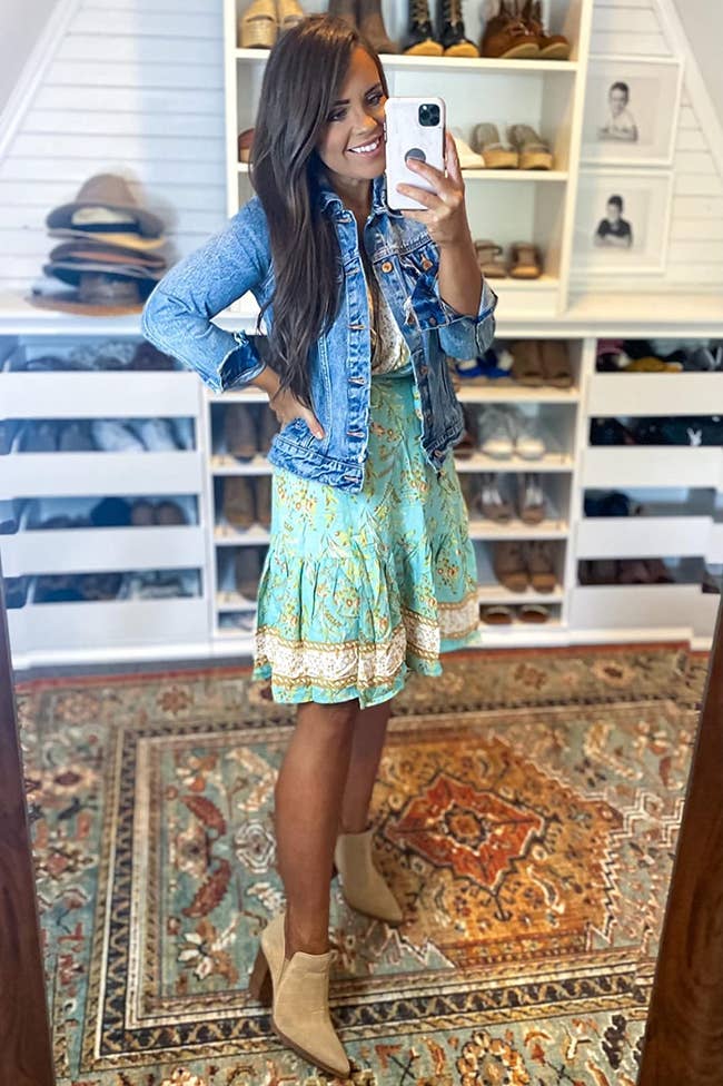 a reviewer wearing the dress with a denim jacket and booties 