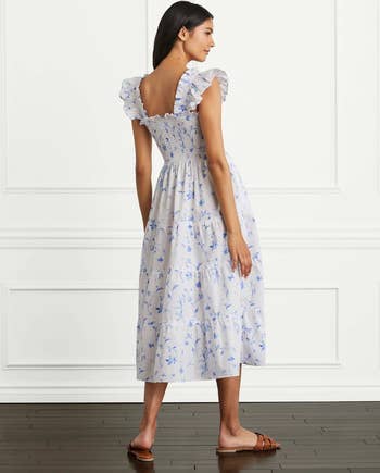 back of model wearing the white dress with blue floral print