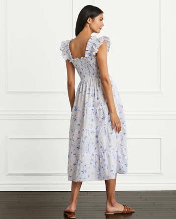 back of model wearing the white dress with blue floral print