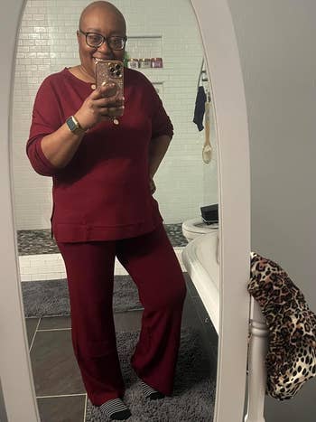 Person in a mirror selfie wearing a casual red top and pants outfit, ideal for a shopping-inspired article