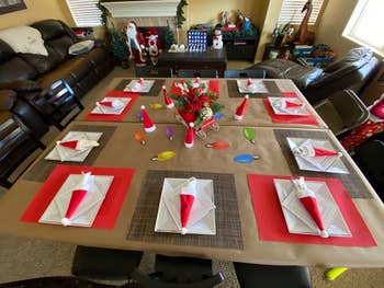 a reviewer's table with red santa hats holding the silverware at each place setting