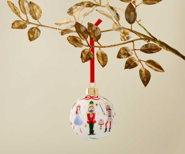 a porcelain ball ornament with characters from the nutcracker on it