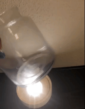 Reviewer video of LED light on with person placing glass vase over it 