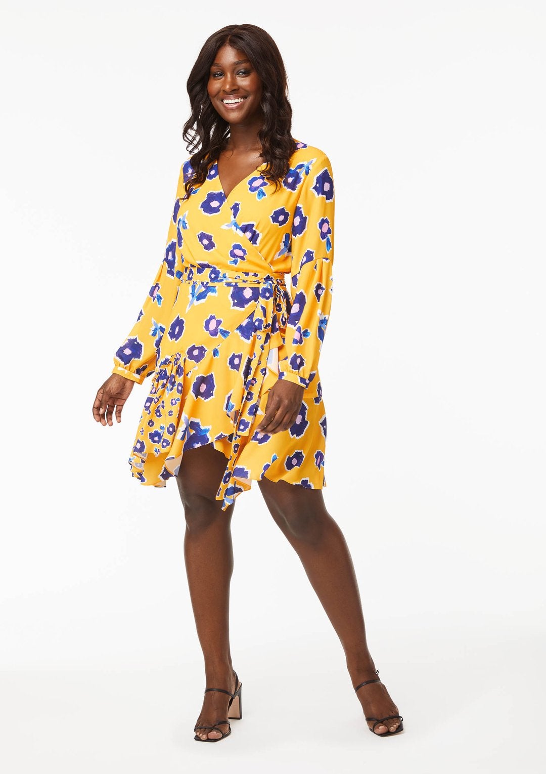 Model wearing yellow-gold dress with blue flowers on it
