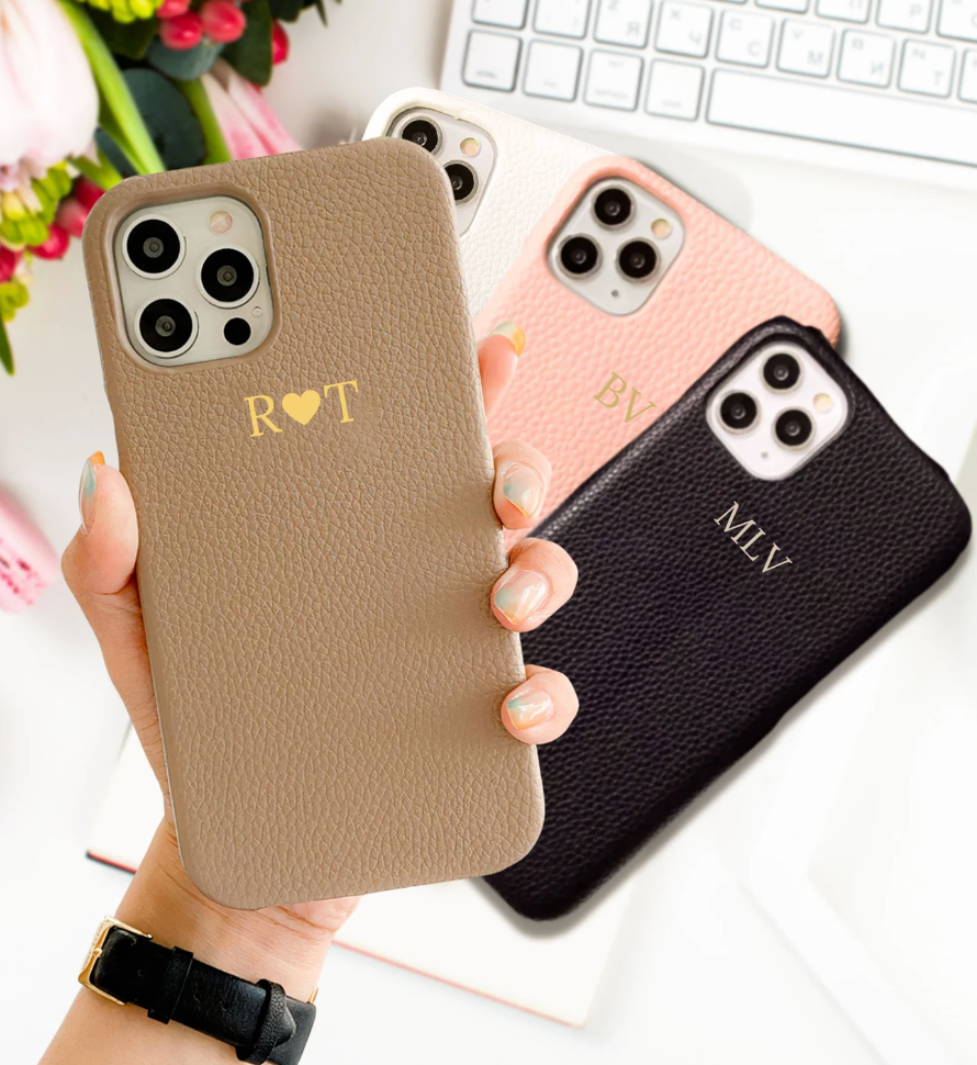 Model holding light brown leather case with monogrammed