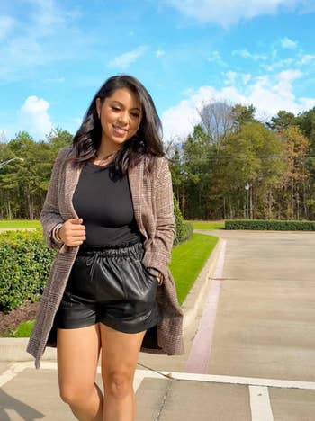 Reviewer wearing black leather shorts walking outside