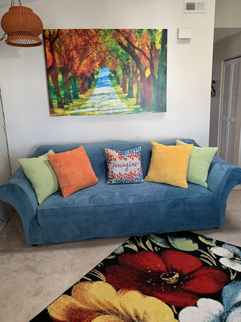a couch with throw pillows in green, yellow, and orange
