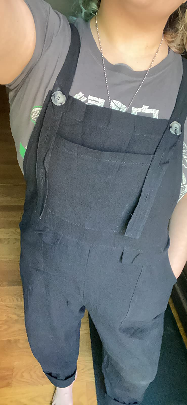 a close-up of the reviewer wearing the overalls showing the front breast pocket and side slip pockets