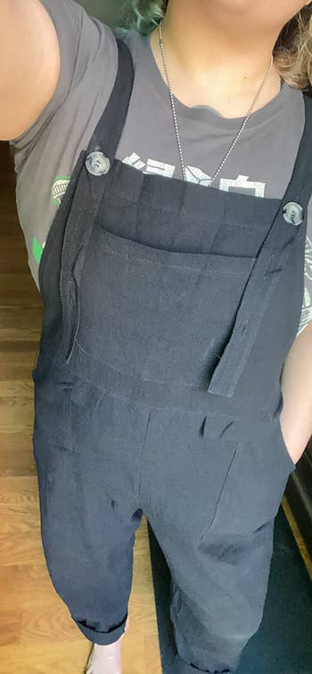 a close-up of the reviewer wearing the overalls showing the front breast pocket and side slip pockets 
