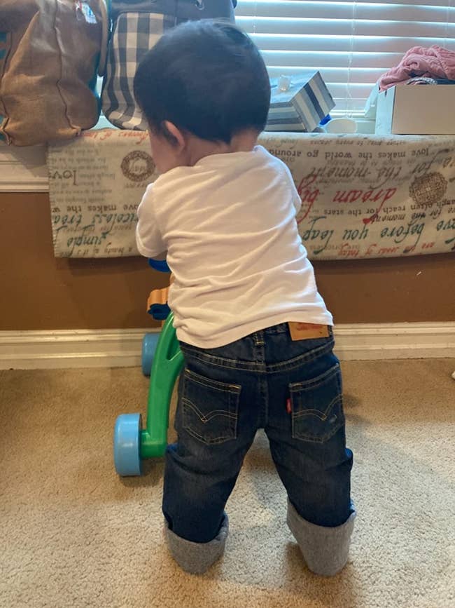 a baby wearing the jeans in a dark wash