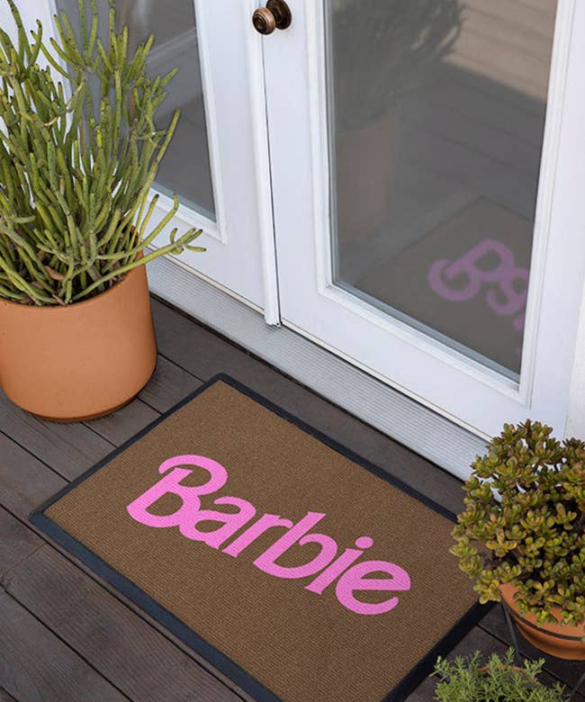 doormat that says barbie on it in light pink font 