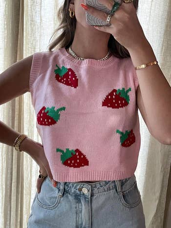 a reviewer wearing the pink strawberry sweater