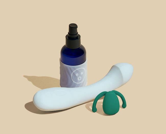 Bottle of Alu lubricant with textured grip sleeve, light blue G-spot vibrator and dark green hands-free vibrator