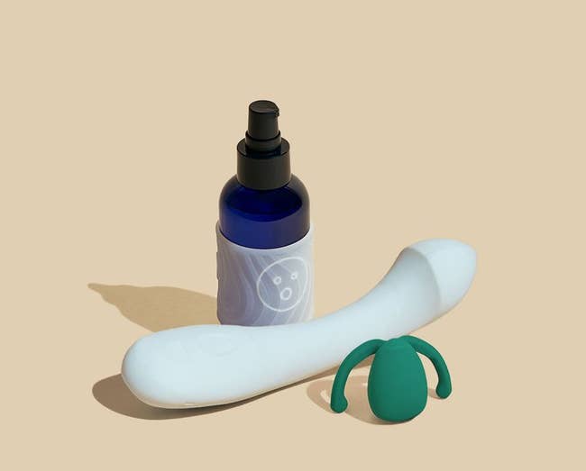 Bottle of Alu lubricant with textured grip sleeve, light blue G-spot vibrator and dark green hands-free vibrator