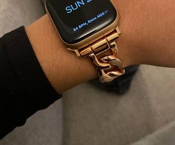 side view of a reviewer wearing the gold apple watch band