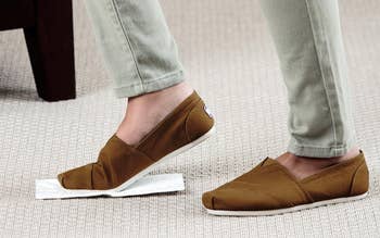 Person wearing slip-on shoes stepping connected  a sticky bug trap connected  a carpeted floor