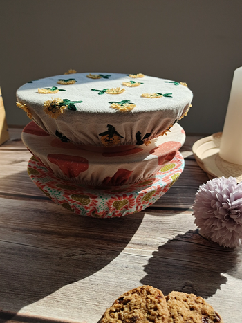 Three bowls stacked with different floral covers over them 