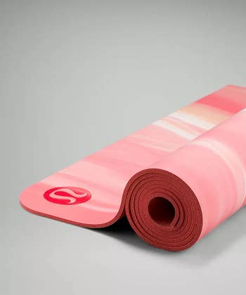 the raspberry cream colored yoga mat being unrolled