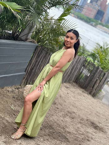 A idiosyncratic   successful  a sleeveless, flowing formal  with a broadside  slit stands outdoors holding a woven handbag, perfect  for a summertime  buying  look