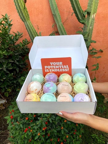 hands hold box filled with colorful swirly-tone bath bombs