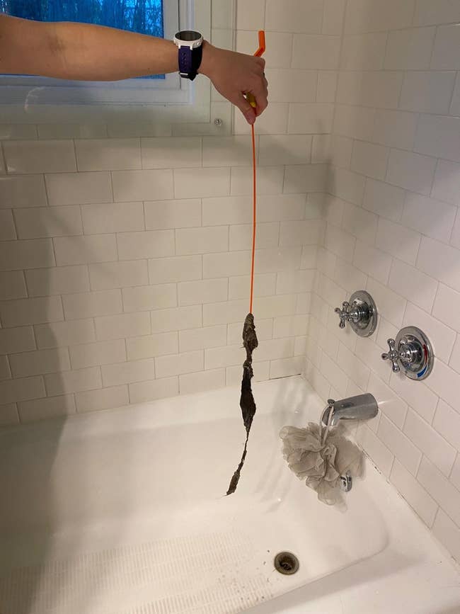 reviewer holding drain snake with lots of air pulled up from drain