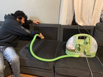 Reviewer using the Bissell machine to clean their couch