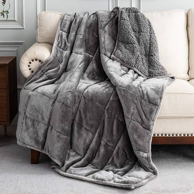 The grey weighted blanket draped over a couch