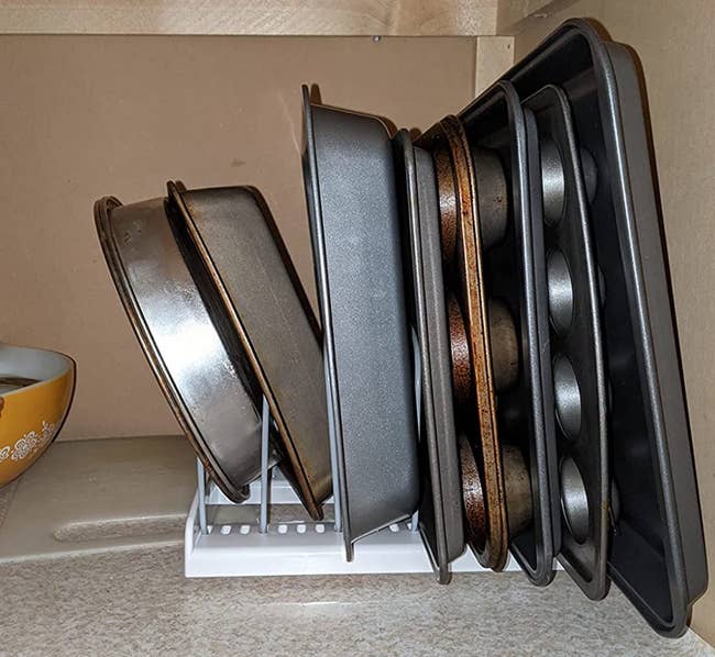 reviewer photo of various pieces of bakeware organized on the bakeware rack