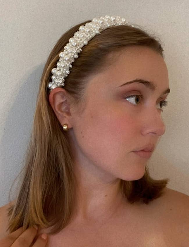 Reviewer in a white headband decorated with faux pearls of various sizes 