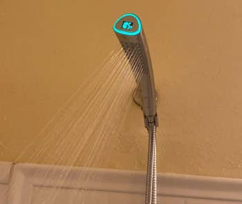 Reviewer's shower head running with temperature lit green at 105 degrees 