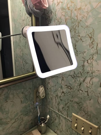 reviewer photo of lit mirror mounted in bathroom mirror