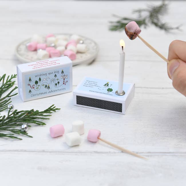 a mini marshmallow on a toothpick toasting over a candle