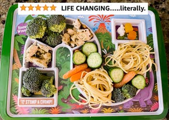 reviewer's photo of the tray with divided sections holding broccoli, cucumber, carrots, and other foods