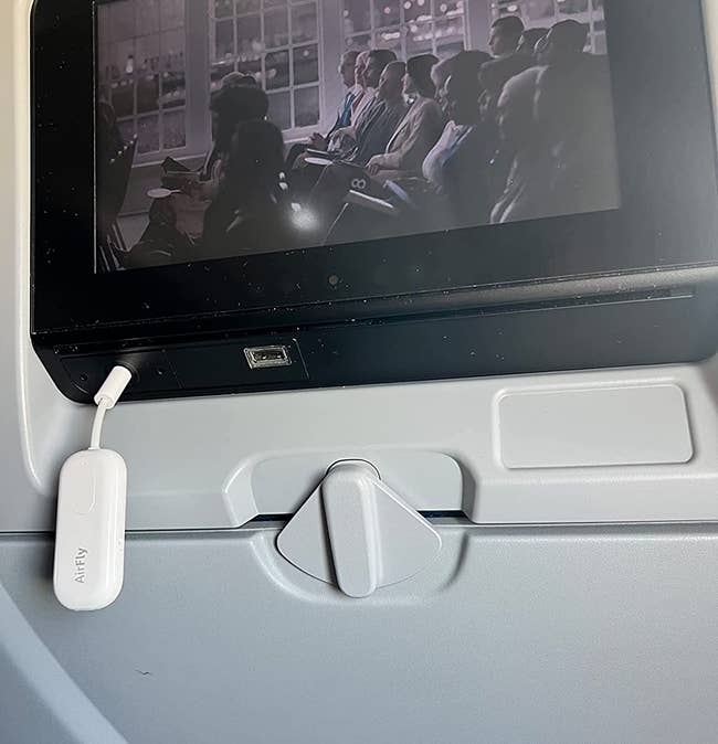 reviewer image of the AirFly plugged into a plane's monitor