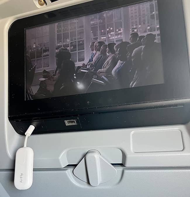 reviewer representation of the AirFly plugged into a plane's monitor