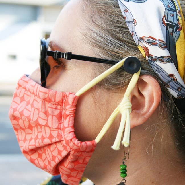 model with mask hooked on the product, which is on the arm of their glasses
