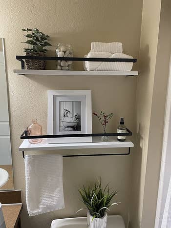 reviewer photo of the white and black shelves in their bathroom